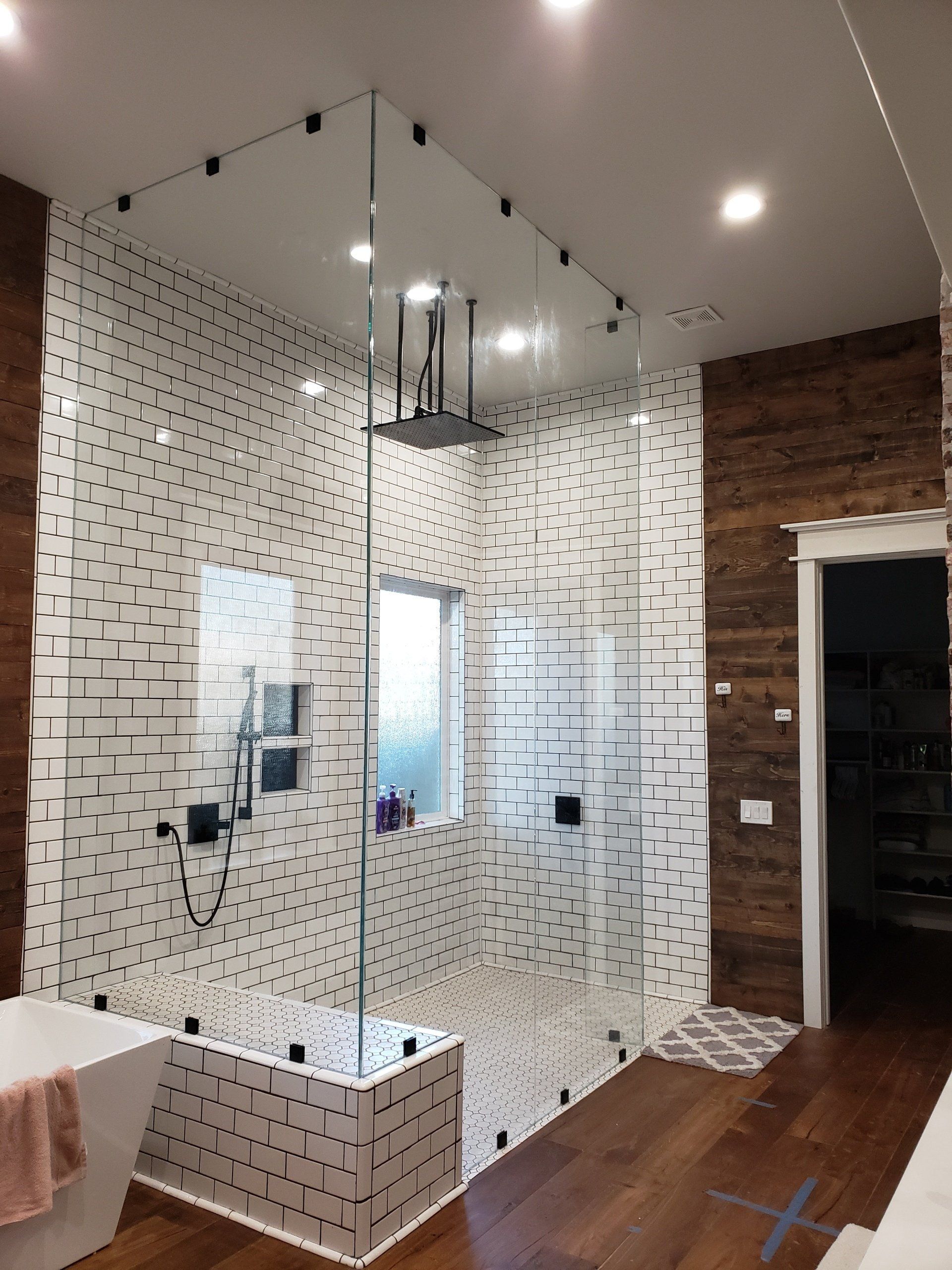 A bathroom with a walk in shower and a bathtub.